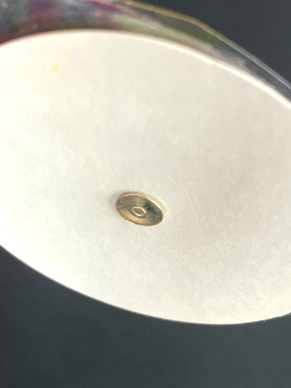 Close-up of white ceramic surface with metal screw