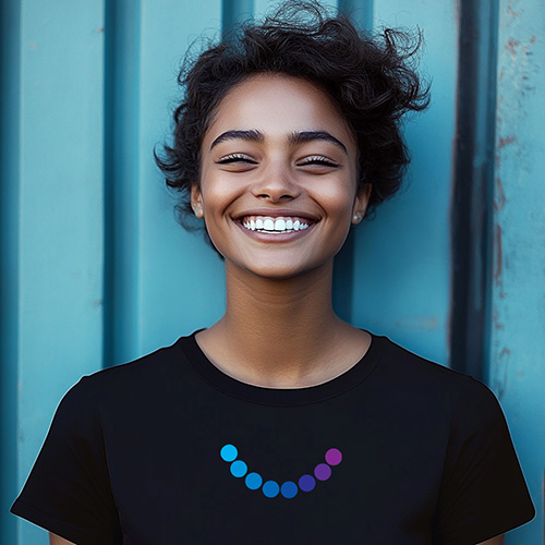 black shirt with a print of 8 circles in a 1/3 upward arced circle that transition from cyan to purple from left to right. The shirt is on a smiling woman in front of a cyan wall