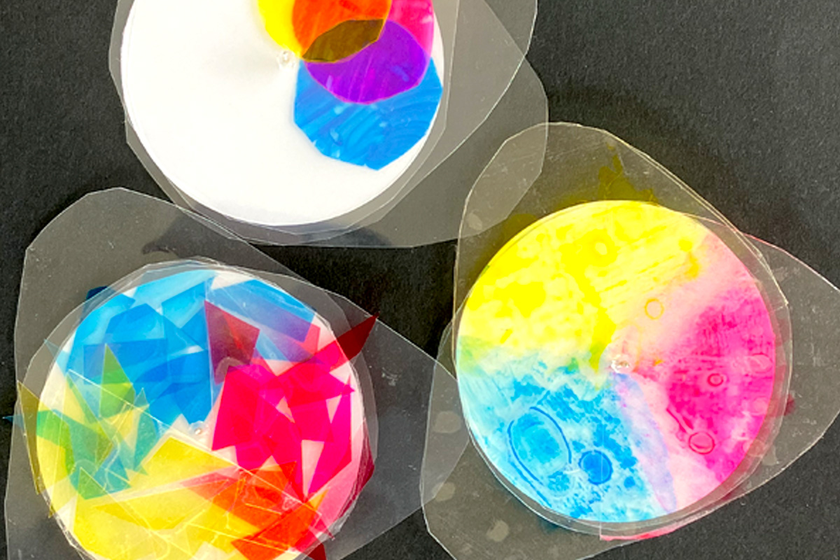 Colourful abstract resin art discs on black surface